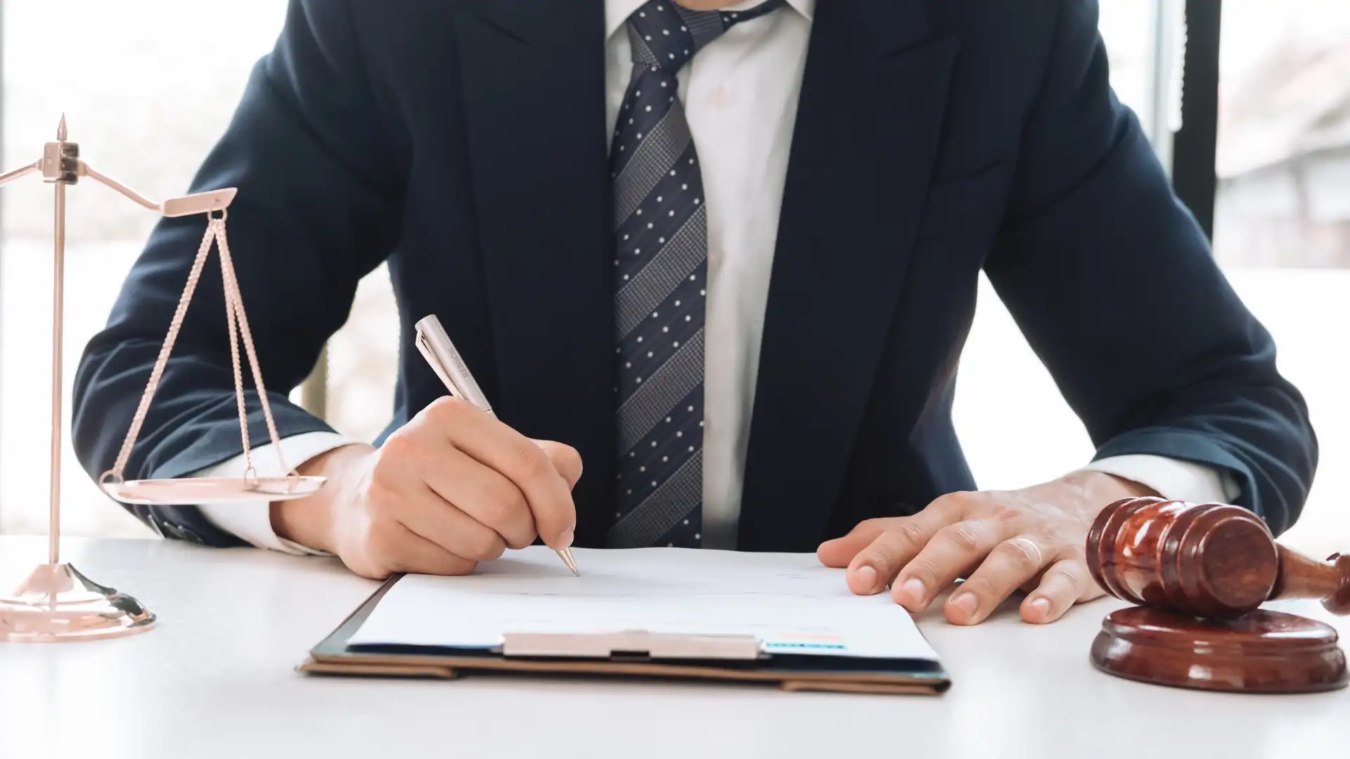 Close-up of a lawyer signing documents at a desk.