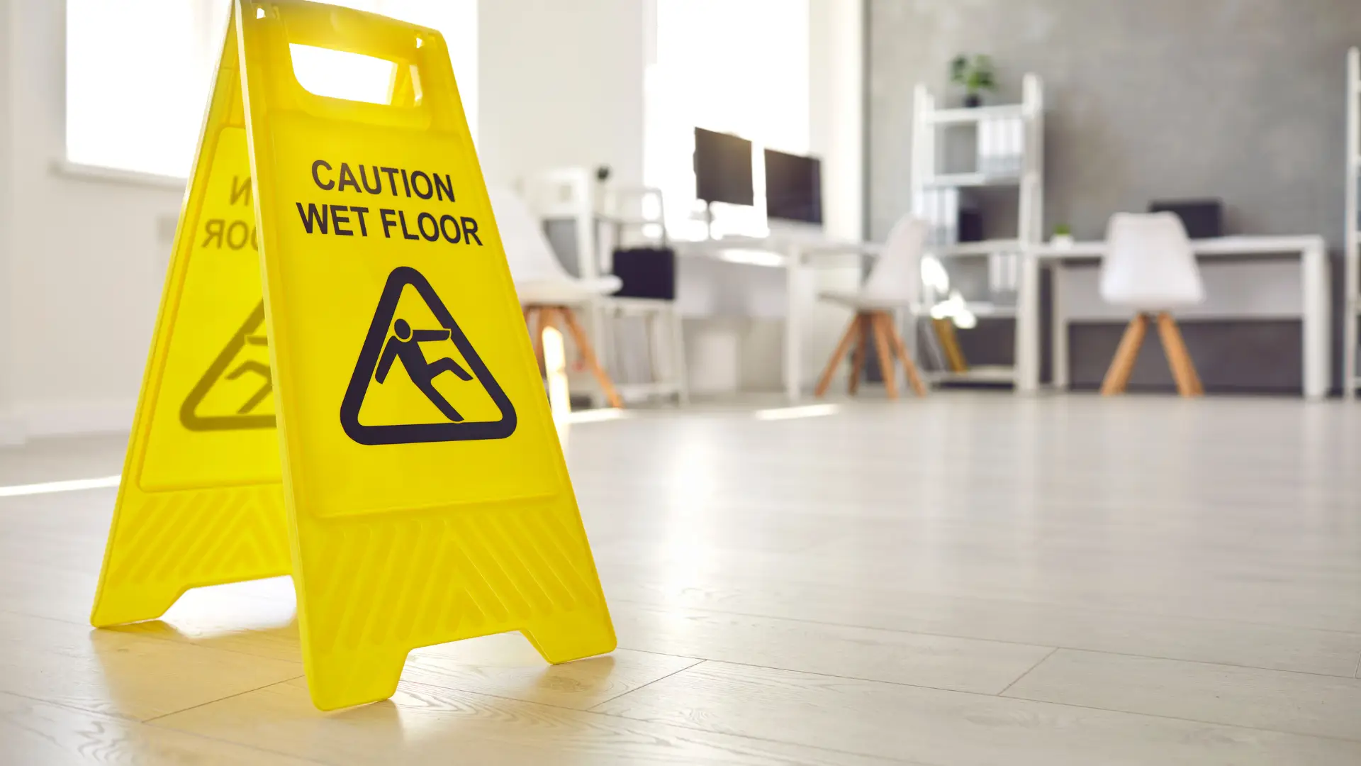 Close-up of a wet floor caution sign in an office setting.