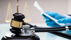 Gavel and stethoscope with doctor reviewing documents
